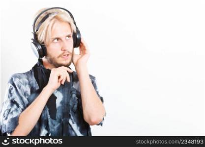 Young people, relax and passion concept. Passionate music lover stylish guy with headphones listening music, relaxing enjyoing, studio shot on white copy space. cool guy having fun listens to music in headphones