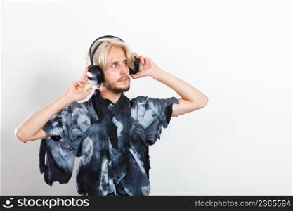 Young people, relax and passion concept. Passionate music lover stylish guy with headphones listening music, relaxing enjyoing, studio shot on white. cool guy having fun listens to music in headphones