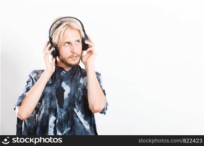 Young people, relax and passion concept. Passionate music lover stylish guy with headphones listening music, relaxing enjyoing, studio shot on white copy space. cool guy having fun listens to music in headphones