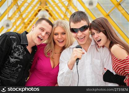 young people sing in microphone on footbridge