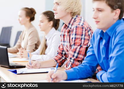 Young people sitting in classroom at lecture. Students at lesson