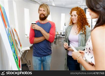 Young people standing in a gallery and contemplating artwork. Young people standing in a gallery and contemplating abstract artwork