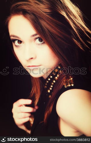 Young people teenage concept - pensive serious woman portrait, fashion teenager girl wearing blouse with gold metal stud on black