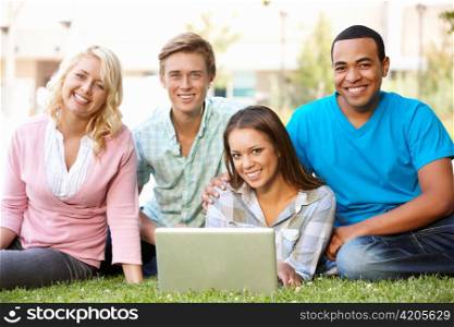 Young people using laptop outdoors