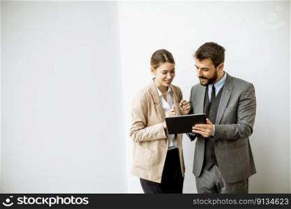 Young people with digital tablet by the wall  in the modern office
