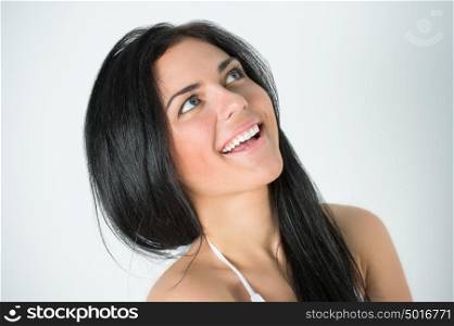 Young positive woman looking upwards and smiling