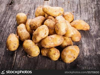 Young potato heap on a wooden background