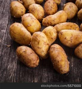 Young potato heap on a wooden background
