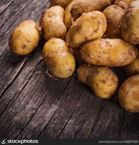 Young potato heap on a wooden background