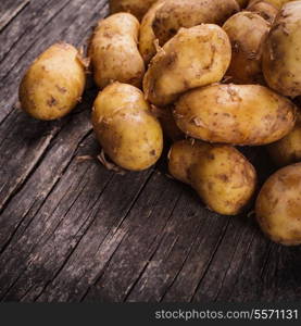 Young potato heap on a wooden background