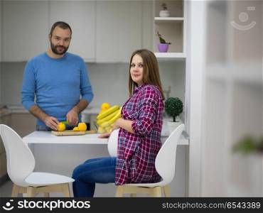 young pregnant couple cooking food fruit lemon juice at kitchen, lifestyle healthy pregnancy happy life concept. couple cooking food fruit lemon juice at kitchen