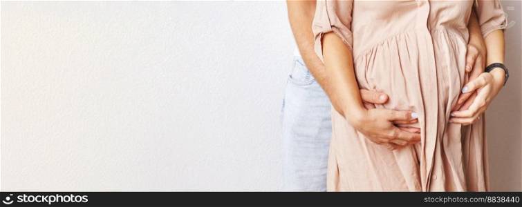 Young pregnant woman and husband hugging her belly close. banner.. Young pregnant woman and husband hugging her belly close. banner