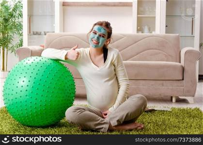 Young pregnant woman doing exercises at home 