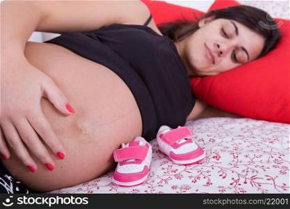 young pregnant woman in bed, focus on the belly