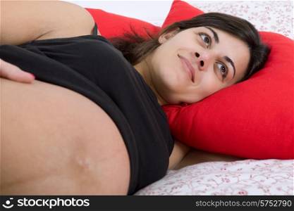 young pregnant woman in bed, focus on the belly