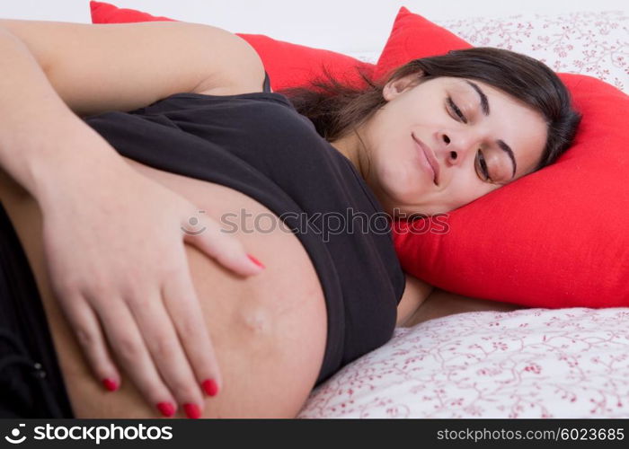 young pregnant woman in bed, focus on the belly