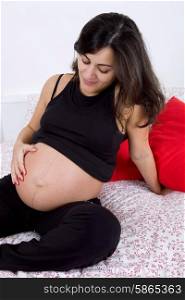 young pregnant woman in bed, studio picture