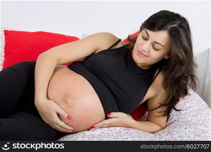 young pregnant woman in bed, studio picture
