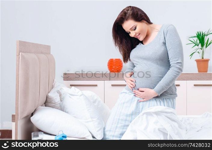Young pregnant woman in the bedroom 