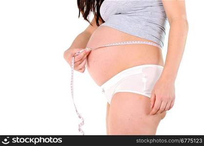 young pregnant woman measuring her belly