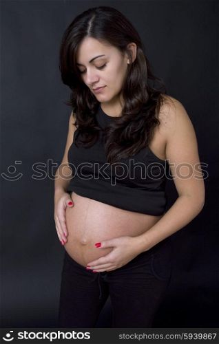 young pregnant woman, on a black background