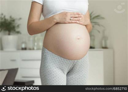 Young pregnant woman on the 9 month posing at home