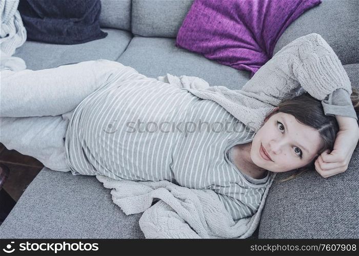 Young pregnant woman relaxing at home