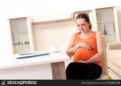 Young pregnant woman working at home 