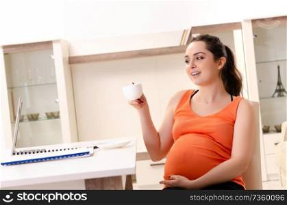 Young pregnant woman working at home