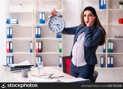 Young pregnant woman working in the office 