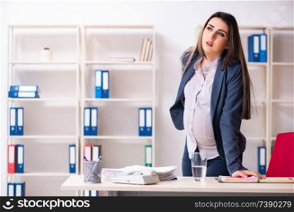 Young pregnant woman working in the office 