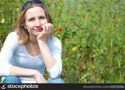 Young pretty blond woman in the green field