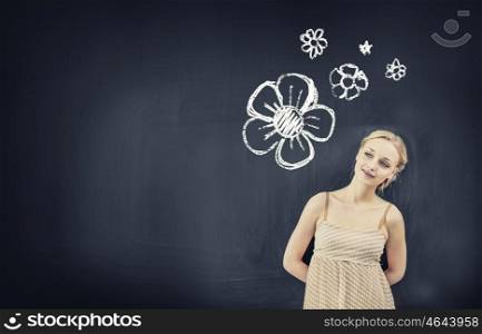Young pretty blond woman teacher near blackboard. Attractive woman