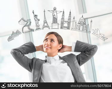 Young pretty business woman dreaming about vacation and her trip to famous touristic destination. Architecture symbols overhead