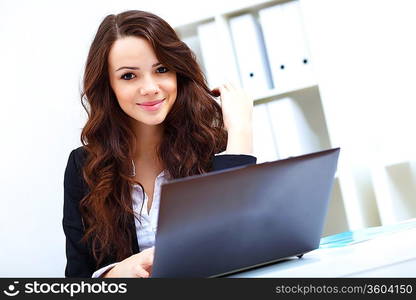 Young pretty business woman with notebook in the office