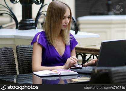 Young pretty business woman with notebook in the office