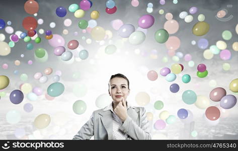 Young pretty businesswoman looking thoughtfully over head. Thoughtful businesswoman