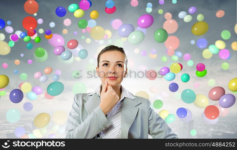 Young pretty businesswoman looking thoughtfully over head. Thoughtful businesswoman