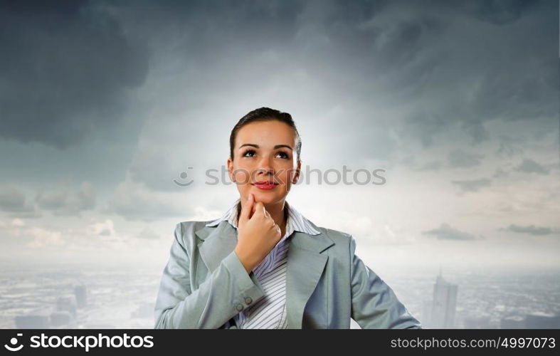 Young pretty businesswoman looking thoughtfully over head. Thoughtful businesswoman