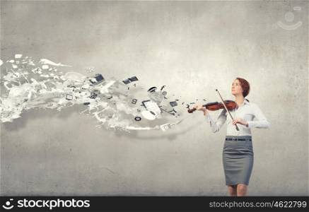 Young pretty businesswoman on cement background playing violin. My business melody
