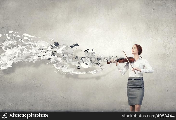 Young pretty businesswoman on cement background playing violin. My business melody