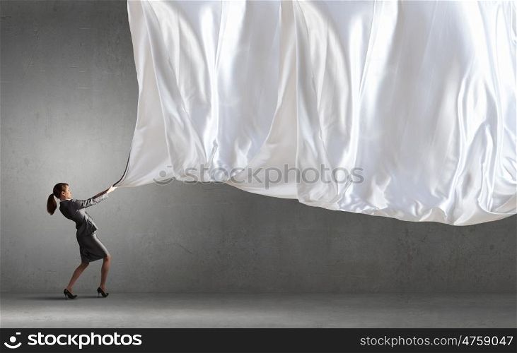 Young pretty businesswoman pulling white blank banner. Woman pull curtain