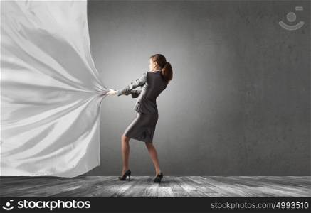 Young pretty businesswoman pulling white blank banner. Woman pull curtain