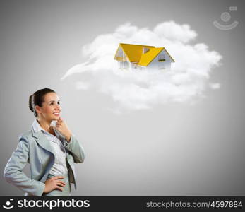 Young pretty businesswoman with houses over head. Thoughtful businesswoman