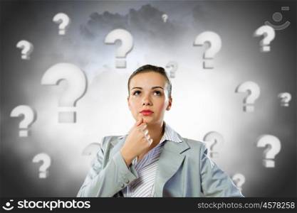 Young pretty businesswoman with question mark over head. Thoughtful businesswoman