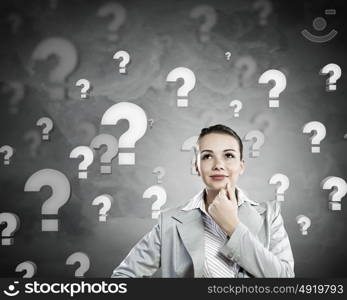 Young pretty businesswoman with question mark over head. Thoughtful businesswoman