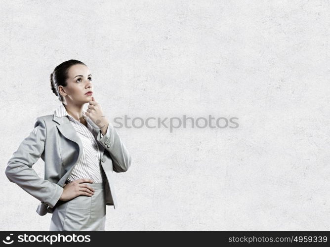 Young pretty businesswoman with question mark over head. Thoughtful businesswoman