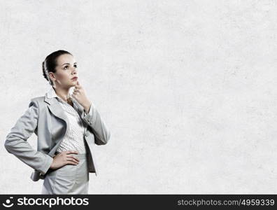 Young pretty businesswoman with question mark over head. Thoughtful businesswoman