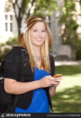Young pretty college girl texting on phone