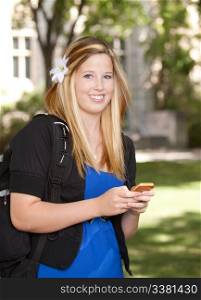 Young pretty college girl texting on phone